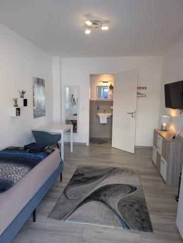 a room with a bed and a living room with a television at Nathalie in Bad Vilbel