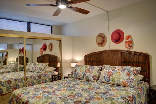 a bedroom with two beds and a ceiling fan at Kihei Akahi C308 in Wailea