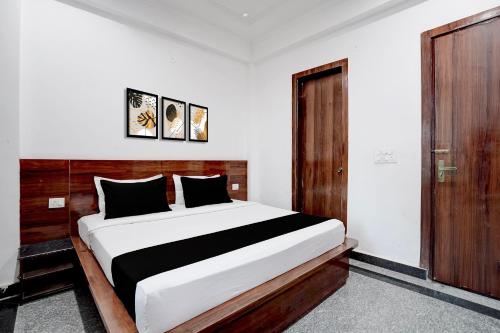 a bedroom with a large bed and a wooden door at Hotel O India Expo Mart Noida Formerly Xponest in Greater Noida