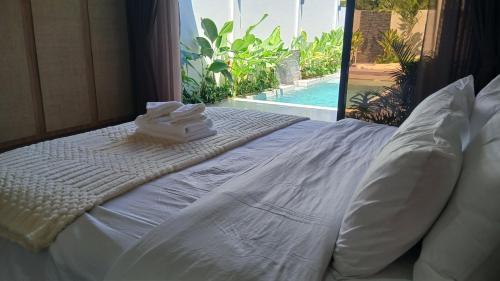 a white bed with two towels on top of it at Taluna Villas in Panglao Island