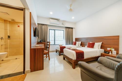 a hotel room with a bed and a bathroom at Hotel Sandra Palace in Thekkady