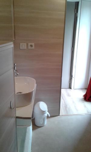 a bathroom with a sink next to a door at Au Passage des Grues in Drosnay