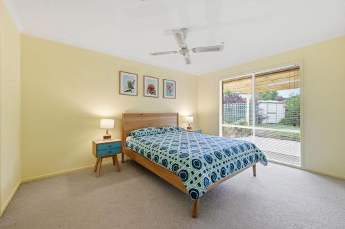 a bedroom with a bed and a window at Serrell by the Sea in Inverloch