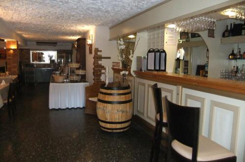 a restaurant with a bar with a wine barrel on the counter at Hôtel U Pozzu in Sisco