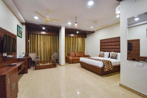 a bedroom with a bed and a desk and a couch at Pineberry Hotels - Near Golden Temple in Amritsar