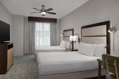a hotel room with two beds and a ceiling fan at Homewood Suites Mobile in Mobile