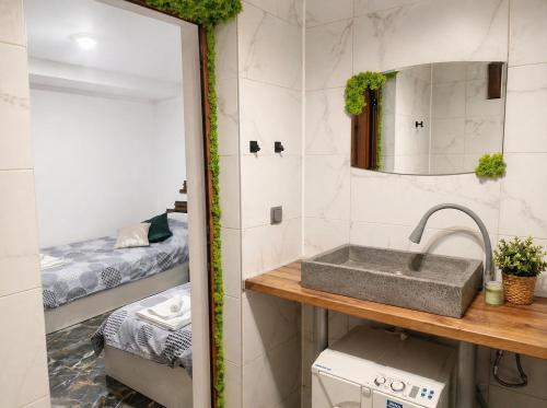 a bathroom with a sink and a bedroom with a bed at Hobbit House in Tsarichino