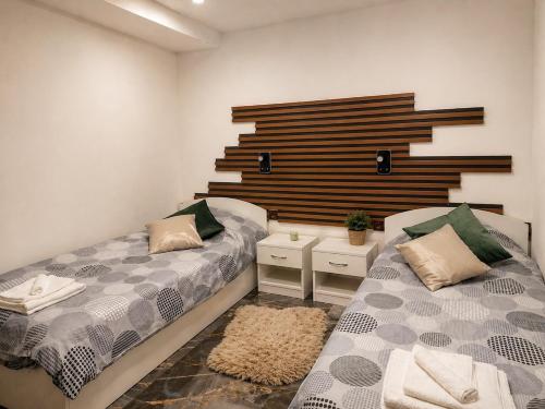 a bedroom with two beds and a wooden wall at Hobbit House in Tsarichino