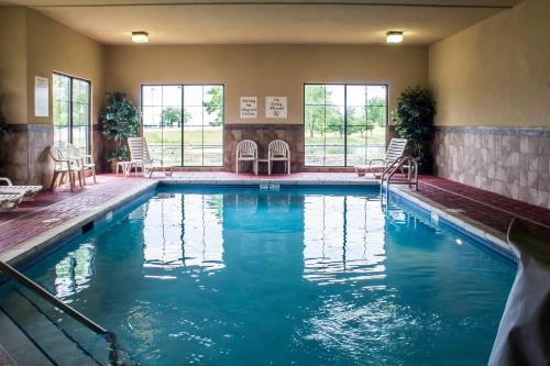 a swimming pool in a hotel with chairs and tables at Econo Lodge Ankeny - Des Moines in Ankeny