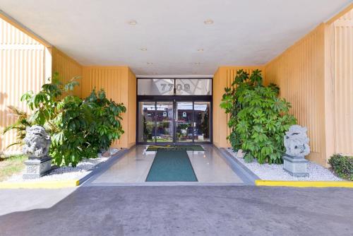 eine Lobby eines Gebäudes mit Bäumen davor in der Unterkunft Quality Inn & Suites Montebello - Los Angeles in Montebello