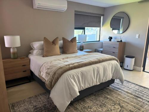 a bedroom with a large bed and a mirror at Mount Glow Self-Catering in Swellendam