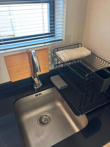 a kitchen with a sink and a shelf above it at Mount Glow Self-Catering in Swellendam
