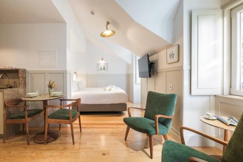 a room with a bed and a table and chairs at Passeio Sintra Collection in Sintra