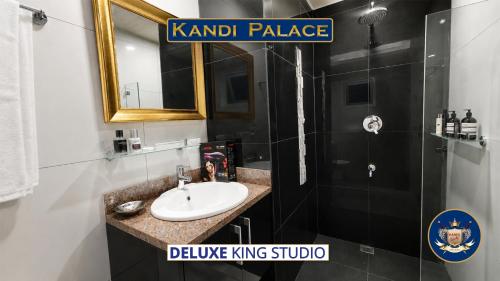 ein Badezimmer mit Waschbecken und Dusche mit Spiegel in der Unterkunft Kandi Palace in Angeles