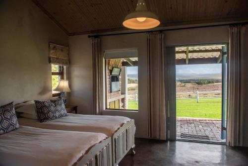 a bedroom with two beds and a sliding glass door at Landmeterskop in Stanford
