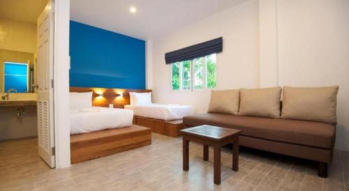 a living room with a couch and a bed at Thalassa Hotel in Ko Tao