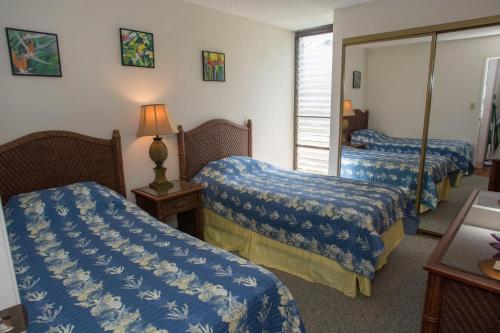 a hotel room with two beds and a mirror at Kihei Holiday 116 in Kihei