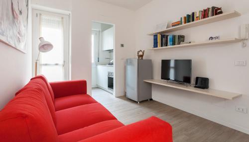 a living room with a red couch and a television at Italianway-Veniero 8 in Milan