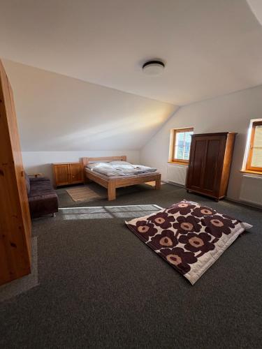 a room with a bed and a rug on the floor at Šumavský dům in Drslavice
