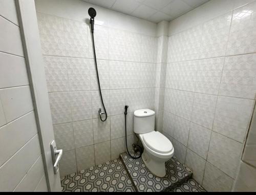 a small bathroom with a toilet and a shower at Hotel O Teratays Homestay in Banda Aceh