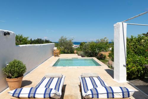 a patio with two lounge chairs and a swimming pool at Ktima Natura in Archangelos