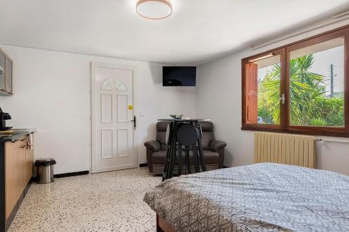 a bedroom with a bed and a chair and a window at les Iris in Pont-Saint-Esprit