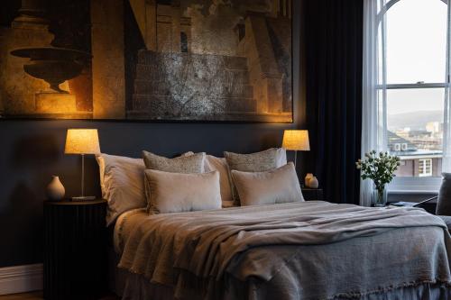a bedroom with a bed with two lamps and a window at Wahroonga on Bourke in Launceston