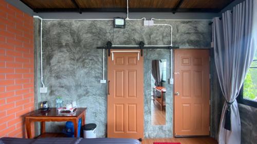 a bedroom with a red door and a brick wall at Love Loft Homestay in Ban Pilok Khi