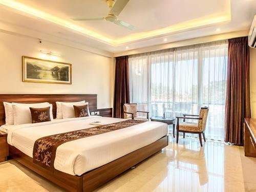a hotel room with a bed and a table and chairs at Hotel Dreamland Mandarmani in Mandarmoni