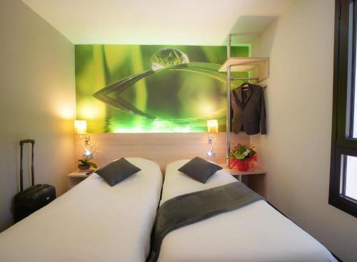 two beds in a room with a painting on the wall at Hôtel Inn Design & Restaurant Vannes Theix-Noyalo in Theix
