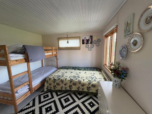 a bedroom with a bunk bed and a desk at Charmig Villa bredvid sjön Örlen in Tibro