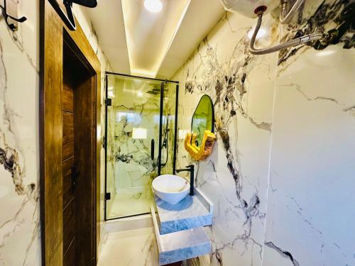 a bathroom with a walk in shower and a sink at Presken Hotel Mojidi, Allen Ikeja in Ikeja