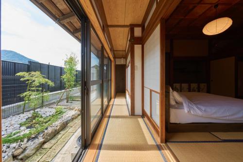 a bedroom with a bed and a large window at つむぎ in Shimoda