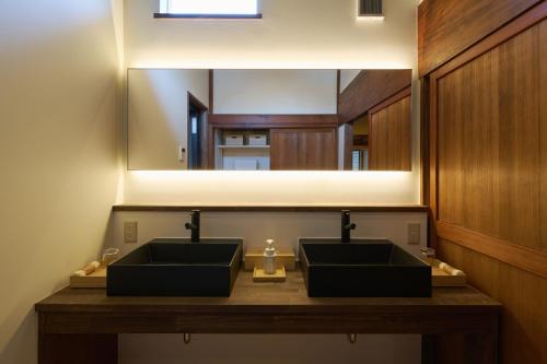 a bathroom with two sinks and a large mirror at つむぎ in Shimoda