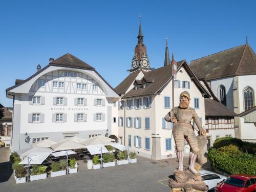 a statue of a man standing in front of a building at Hotel Zofingen in Zofingen