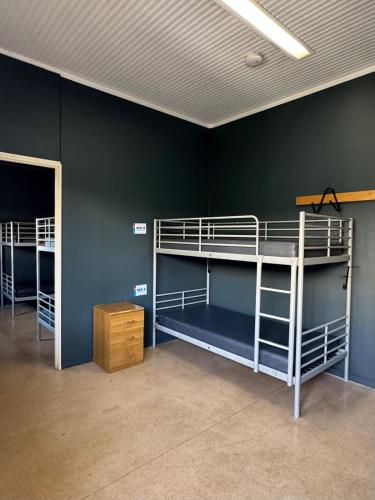two bunk beds in a room with a wall at Roebuck Bay Backpackers in Broome