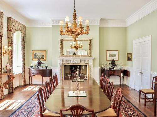 a dining room with a table and a fireplace at Kyre Park in Tenbury