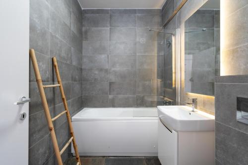 a bathroom with a white tub and a sink at N31 Pipera Executive Apartment in Voluntari