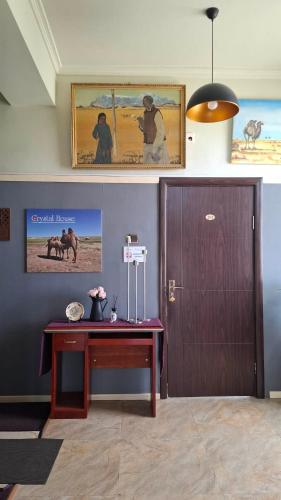 a room with a desk and a wooden door at Crystal House Hotel in Buyant-Uhaa
