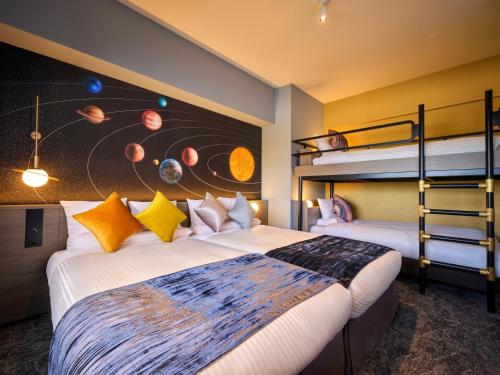 a bedroom with two beds and a bunk bed at Art Hotel Narita in Narita