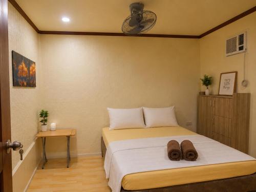 a bedroom with a bed with two shoes on it at Kubo Inn & Beach Camp in El Nido