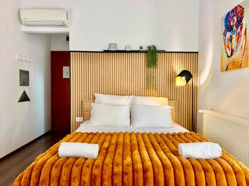 ein Schlafzimmer mit einem großen Bett und zwei Kissen in der Unterkunft Cozy Hideout - Condo Hotel in Timişoara