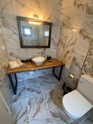 a bathroom with a sink and a mirror and a toilet at MAİ Sarıgerme in Sarigerme