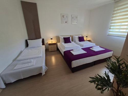 a bedroom with two beds and two lamps in it at Apartments Platz in Mostar