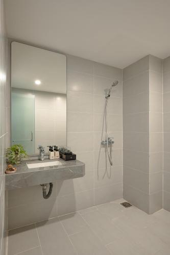 a bathroom with a sink and a shower with a mirror at Amazing Studio Boutique Hotel in Hanoi