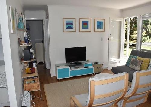 a living room with a tv and a couch at Barefoot Bungalow in Tomakin