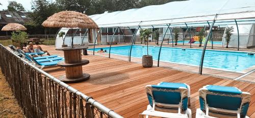 a pool with chairs and a table and a umbrella at Happy Glamping in Wittelte
