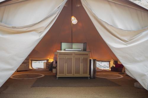 a tent with a tv in the middle of it at La Permaculturelle - Domaine des Ramières in Le Poët-Laval