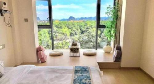 a bedroom with a bed and a large window at Parkside Hostel in Guilin