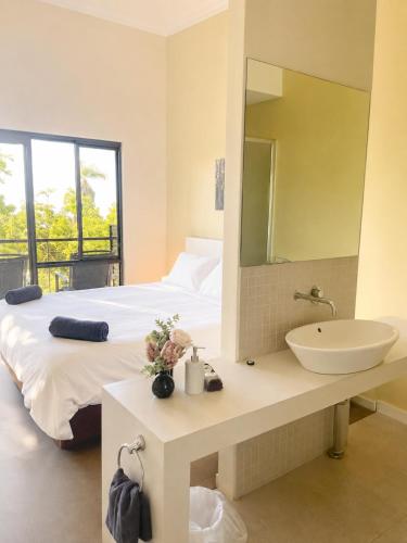a bathroom with a sink and a bed with a mirror at Townhouse 7 - Located at FOOTPRINTS PRESTON BEACH RESORT in Preston Beach